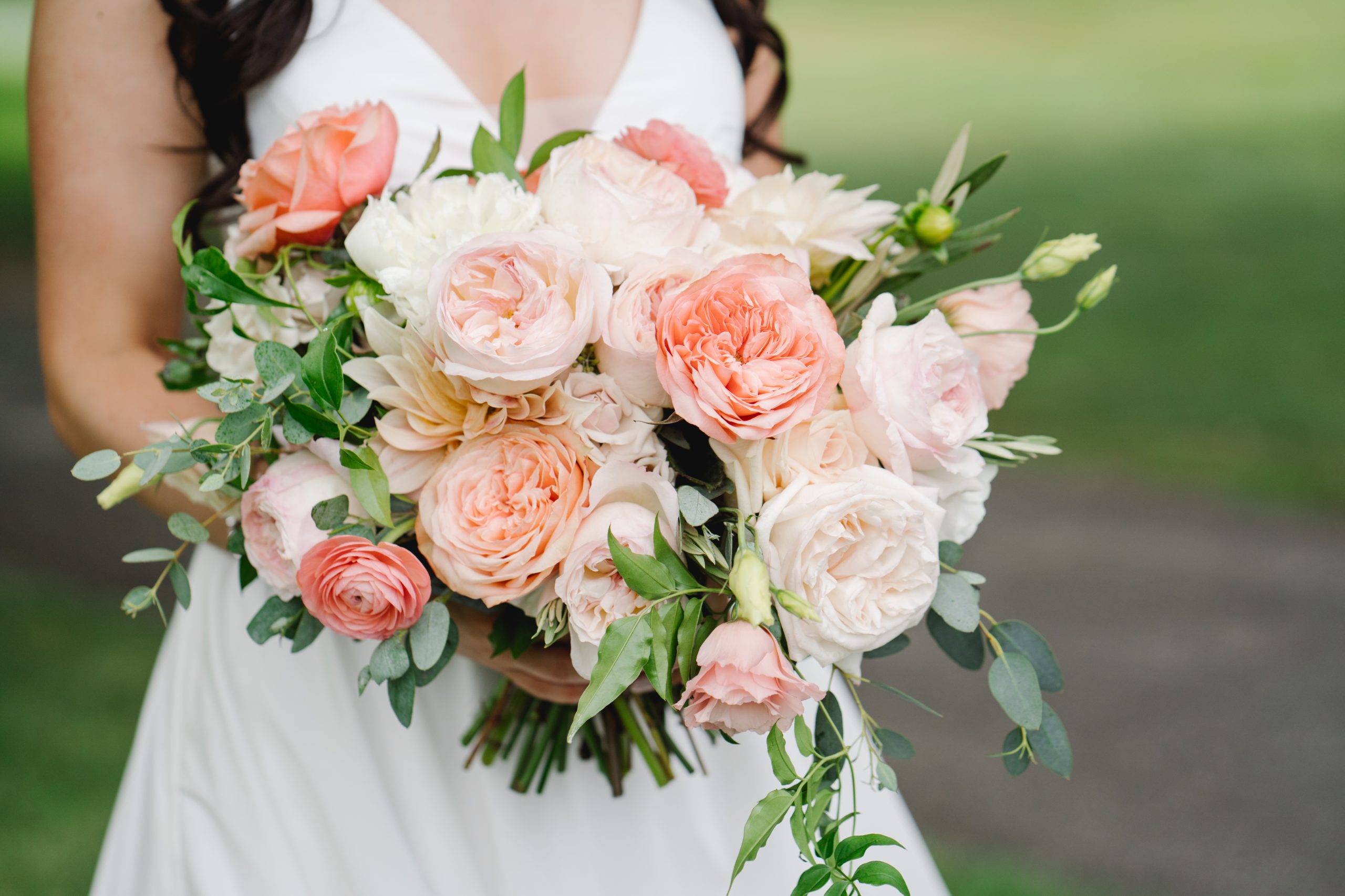 bride holding bouquet of pink, peach, and white garden roses