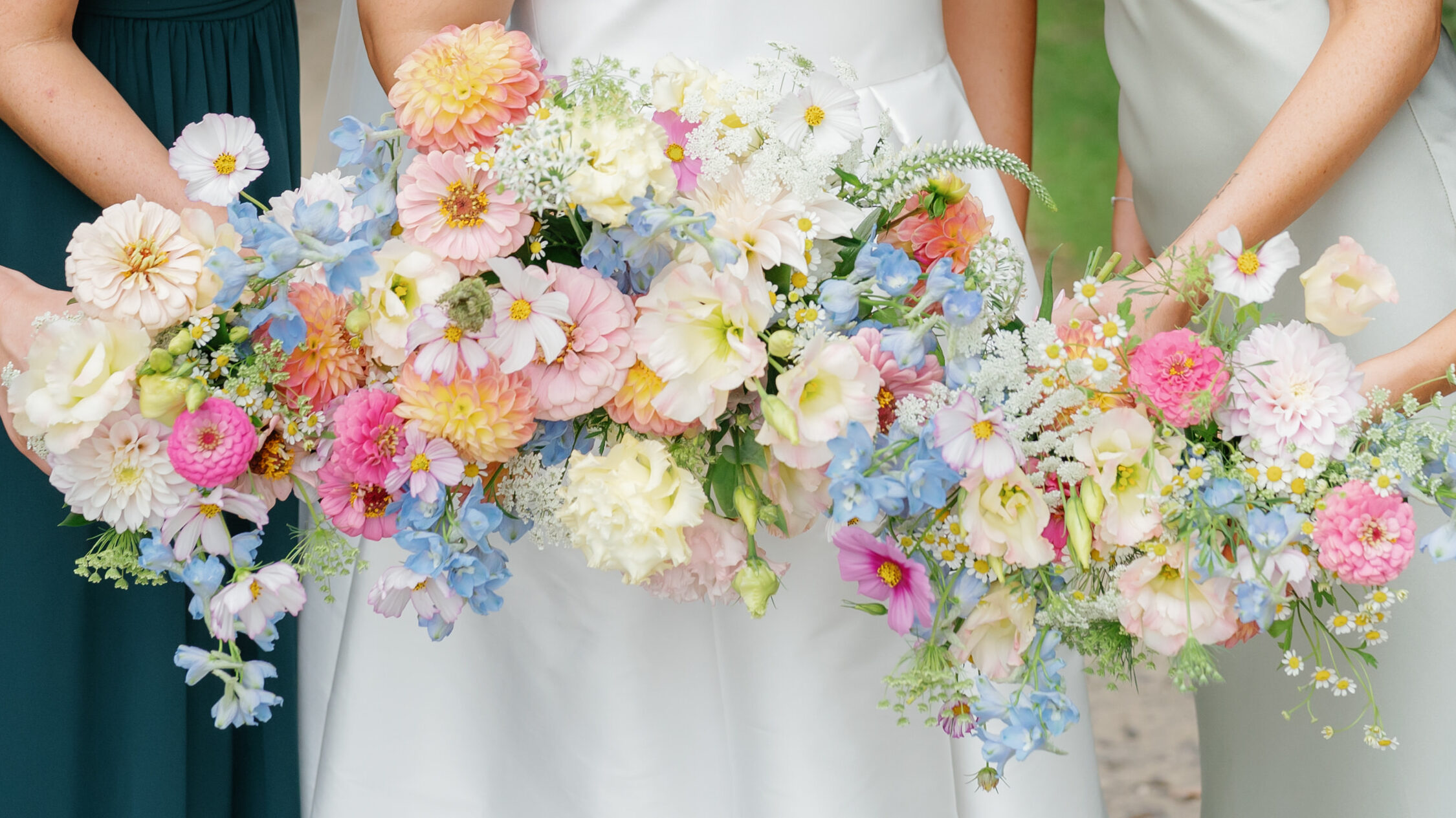 Bridal bouquet with pastel lisianthus, delphinium, and zinnias, captured during a wedding at The Grove at Centerton.